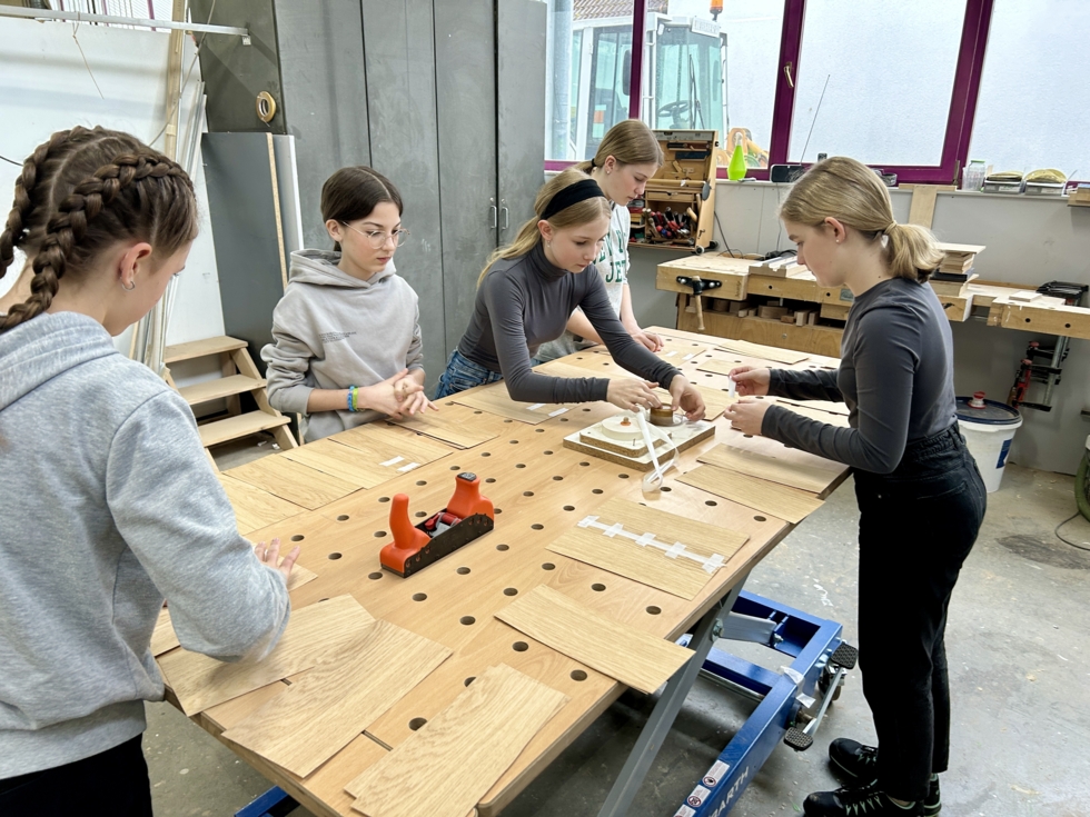 Die Girls'Day-Teilnehmerinnen werken mit Holz.