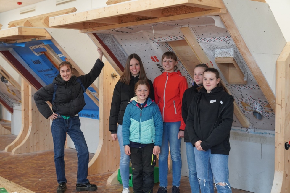 Girls'Day-Teilnehmerinnen mit Mitarbieterin in einem Dachstuhl
